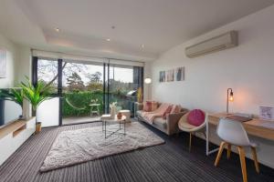 uma sala de estar com um sofá e uma mesa em Trendy 2 bed 2 bath Apartment - Heart of St Kilda em Melbourne