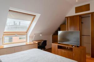 a bedroom with a bed and a tv and a window at Puerto Madero a metros del Faena in Buenos Aires