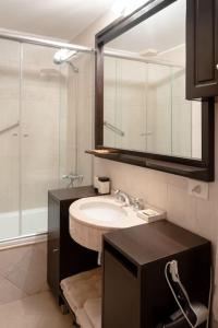 a bathroom with a sink and a shower and a mirror at Puerto Madero a metros del Faena in Buenos Aires