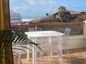 a white table and chairs on a balcony with the ocean at Milady Ocean View in Biarritz