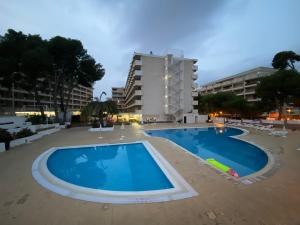 una gran piscina frente a un edificio en Apartamento con servicios, piscina y parking privado máx 4 pax, en Salou