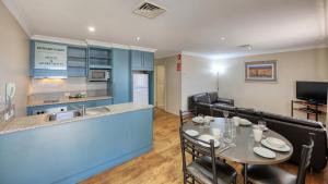 Edward Parry Motel and Apartments في تامفورث: مطبخ وغرفة طعام مع طاولة وكراسي