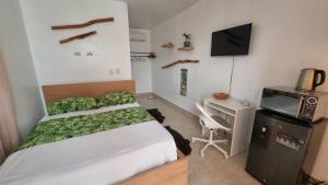 a small bedroom with a bed and a television at Unique and quiet APARTMENTS La Botánica Tropical in Punta Cana