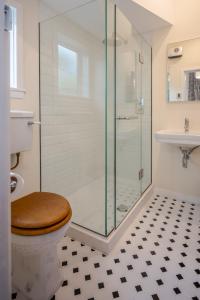 a bathroom with a toilet and a glass shower at French Bay House in Akaroa