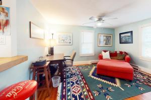 a living room with a red couch and a desk at Cape Cod-age in Falmouth