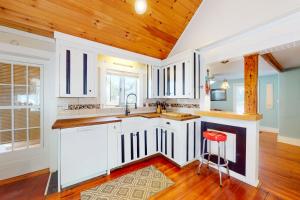a kitchen with white cabinets and a wooden ceiling at Cape Cod-age in Falmouth