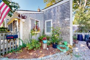 a house with a flag and plants in front of it at Cape Cod-age in Falmouth