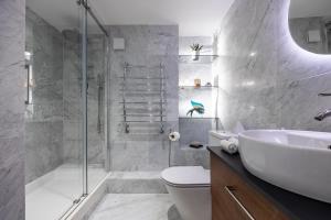 a bathroom with a shower and a sink and a toilet at Nino Homes Kings cross in London