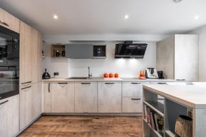 a kitchen with stainless steel appliances and wooden cabinets at Nino Homes Kings cross in London