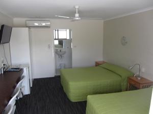 a hotel room with two beds and a window at Urangan Motor Inn in Hervey Bay