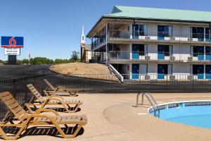 um hotel com piscina e espreguiçadeiras ao lado de um edifício em Motel 6 Branson West, MO - Silver Dollar City em Branson West