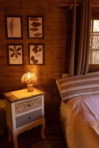 1 dormitorio con 1 cama y 1 mesa con lámpara en Eco-Resort Parco Botanico Fiorlago en Mergozzo