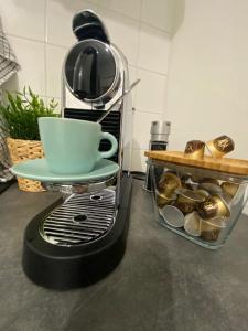 eine Kaffeemaschine mit einer Tasse darüber in der Unterkunft Appartement Chaville in Chaville