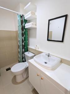 a bathroom with a toilet and a sink and a mirror at Close to Polymedic Medical Plaza with FREE Wi-fi & Netflix in Cagayan de Oro