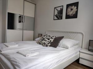 Una cama blanca con dos almohadas encima. en Lux Apartment close to Medicover and Paley, en Varsovia
