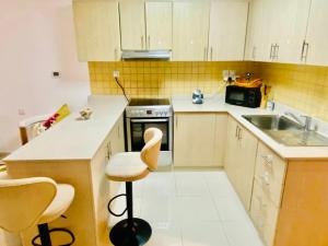 a small kitchen with a sink and a stove at Rixos Beach Apartment in Ras al Khaimah