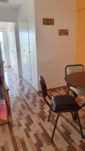 sala de estar con mesa, sillas y suelo de madera. en Hermoso 2 ambientes en Palermo Hollywood en Buenos Aires