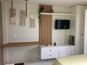 a bedroom with a white dresser and a tv at Flat frente mar na Praia do Pero com piscina in Cabo Frio +19 photos
