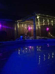 a swimming pool at night with lights on a fence at Hostal Namaste in Salta