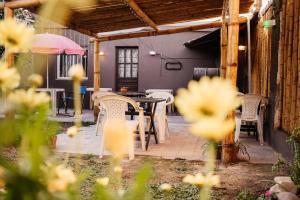 un patio con sillas, una mesa y una sombrilla en Hostal Namaste en Salta