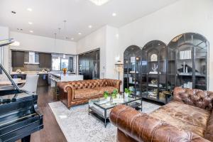 a living room with leather furniture and a piano at Skyline Loft in Houston