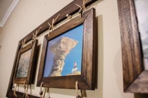a picture frame hanging on a wall with a person standing on a rock at Hostal Namaste in Salta