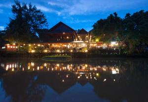 un edificio con luci di fronte a un lago di notte di Sepilok Nature Lodge - Formerly known as Sepilok Nature Resort a Sandakan