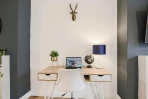 a desk with a white chair and a laptop on it at Central House with Free Parking, Garden, Super-Fast Wifi and Smart TVs by Yoko Property in Northampton