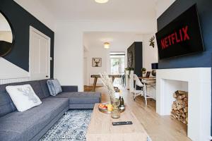 a living room with a couch and a fireplace at Central House with Free Parking, Garden, Super-Fast Wifi and Smart TVs by Yoko Property in Northampton