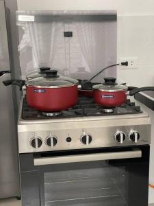 - une cuisine avec 2 casseroles au-dessus d'une cuisinière dans l'établissement Exclusivo Apartamento en el Centro Histórico Trujillo - 3er Piso, à Trujillo