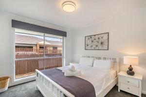 a bedroom with a bed and a large window at Central Park in Port Fairy