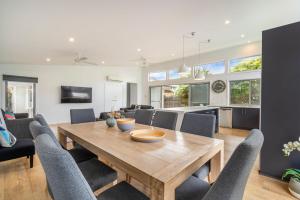 a dining room and living room with a wooden table and chairs at Central Park in Port Fairy