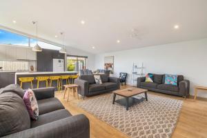 a living room with two couches and a kitchen at Central Park in Port Fairy