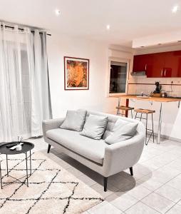 a living room with a couch and a kitchen at Élégant T2 Blagnac - parking -aéroport-Airbus- Meett in Blagnac