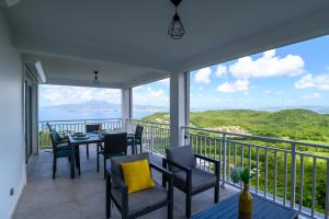a balcony with a table and chairs and a view of the ocean at VILLA EDINA , Exceptionnel aux Trois ILETS,T3 vue incroyable sur FDF in Les Trois-Îlets