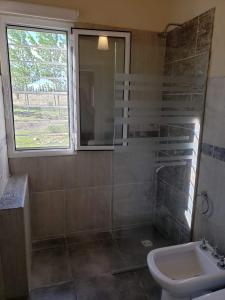 baño con lavabo y aseo y ventana en Aldea Amedo en San Rafael