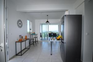 a kitchen and dining room with a table and a refrigerator at VILLA EDINA , Exceptionnel aux Trois ILETS,T3 vue incroyable sur FDF in Les Trois-Îlets