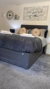 czarne łóżko z dwoma poduszkami w sypialni w obiekcie Bv Homely Studio Fifteen At Deighton Huddersfield w mieście Huddersfield