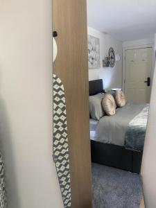 sypialnia z łóżkiem i lustrem w obiekcie Bv Homely Studio Fifteen At Deighton Huddersfield w mieście Huddersfield