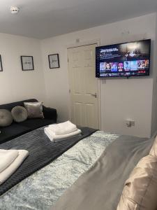 a bedroom with a bed and a flat screen tv at Bv Homely Studio Fifteen At Deighton Huddersfield in Huddersfield