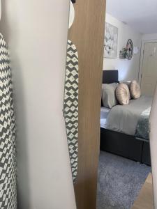 a small bedroom with a bed and a mirror at Bv Homely Studio Fifteen At Deighton Huddersfield in Huddersfield