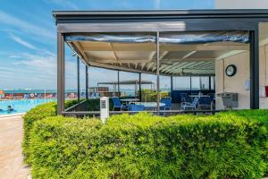 a covered patio with blue chairs and a pool at La Puerta Island Retreat with Florida Flair in St Petersburg