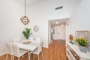 a white dining room with a white table and chairs at Vista Verde E Beautifully Updated, Contemporary Condo in St Petersburg