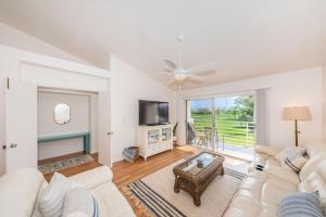a living room with a white couch and a television at Vista Verde E Beautifully Updated, Contemporary Condo in St Petersburg