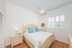 a white bedroom with a bed and a ceiling fan at Vista Verde E Beautifully Updated, Contemporary Condo in St Petersburg +9 photos