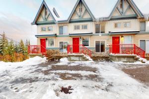 una casa con puertas rojas en la nieve en Tree Tops 35, en Big White
