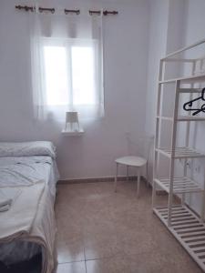 1 dormitorio con cama, estante y ventana en Apartamento Las Brisas, en Rincón de la Victoria