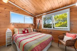 a bedroom with a bed and two windows at Barne the Bentley - Taupo Holiday Home in Taupo