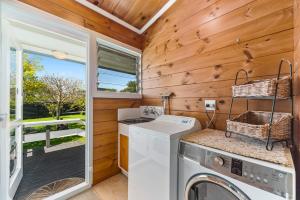 a small laundry room with a washer and dryer at Barne the Bentley - Taupo Holiday Home in Taupo