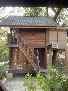 a small wooden house with a staircase in a tree at The Temak Villa in Pantai Cenang